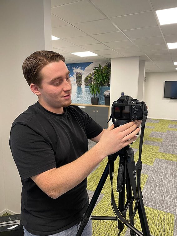 stagiair met camera op statief close-up