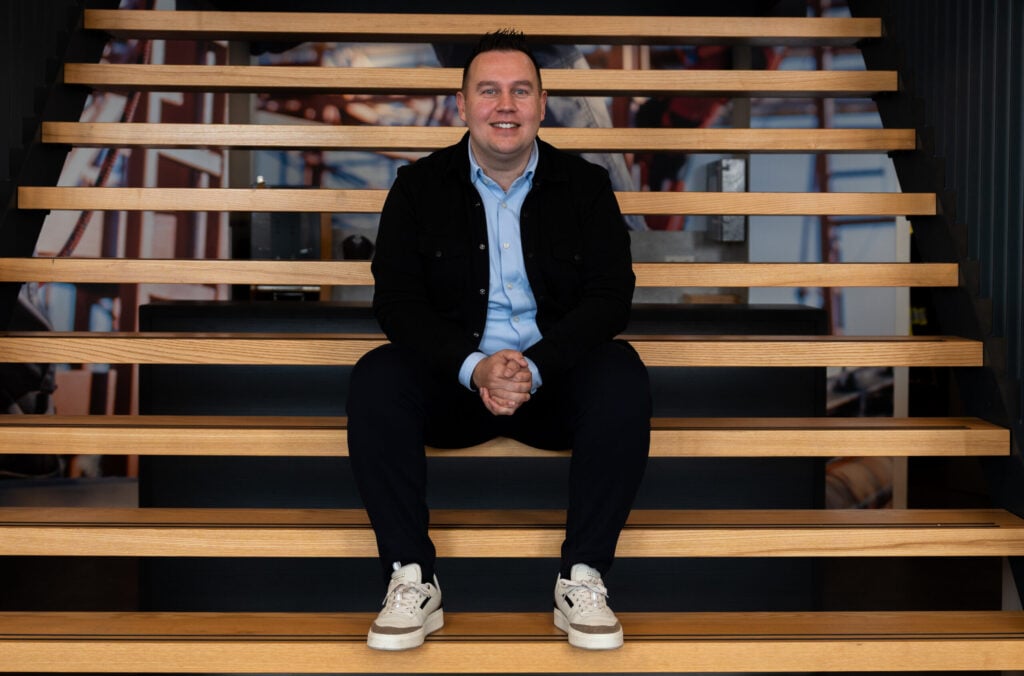RUebn zit op de trap bij VDIJ ontspannen en vrolijke blik