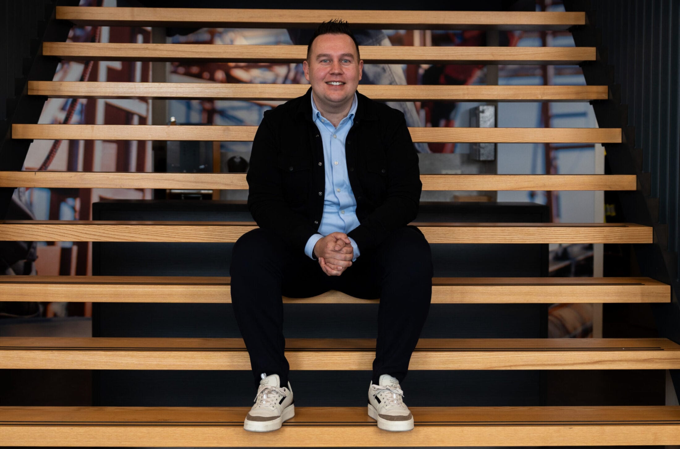 RUebn zit op de trap bij VDIJ ontspannen en vrolijke blik