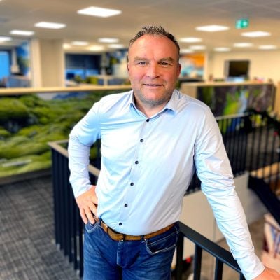 mark staat op het kantoor bij een trap en kijkt recht in de camera