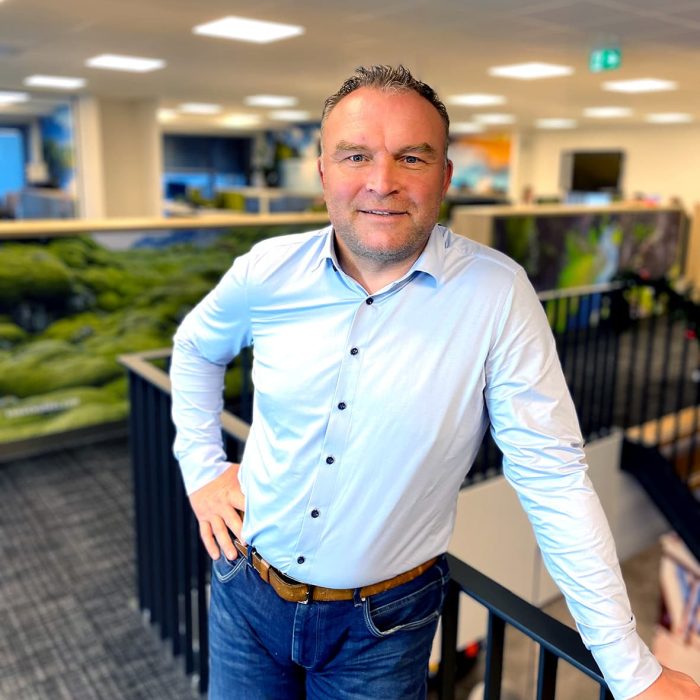 mark staat op het kantoor bij een trap en kijkt recht in de camera